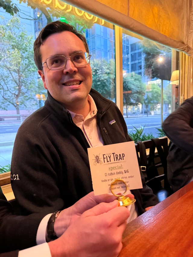 Russell from C1 holding The Fly Trap's specials card featuring the C1 Token Daddy cocktail